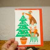 Postal Navidad Riso "Decorando el árbol" X YUK FUN